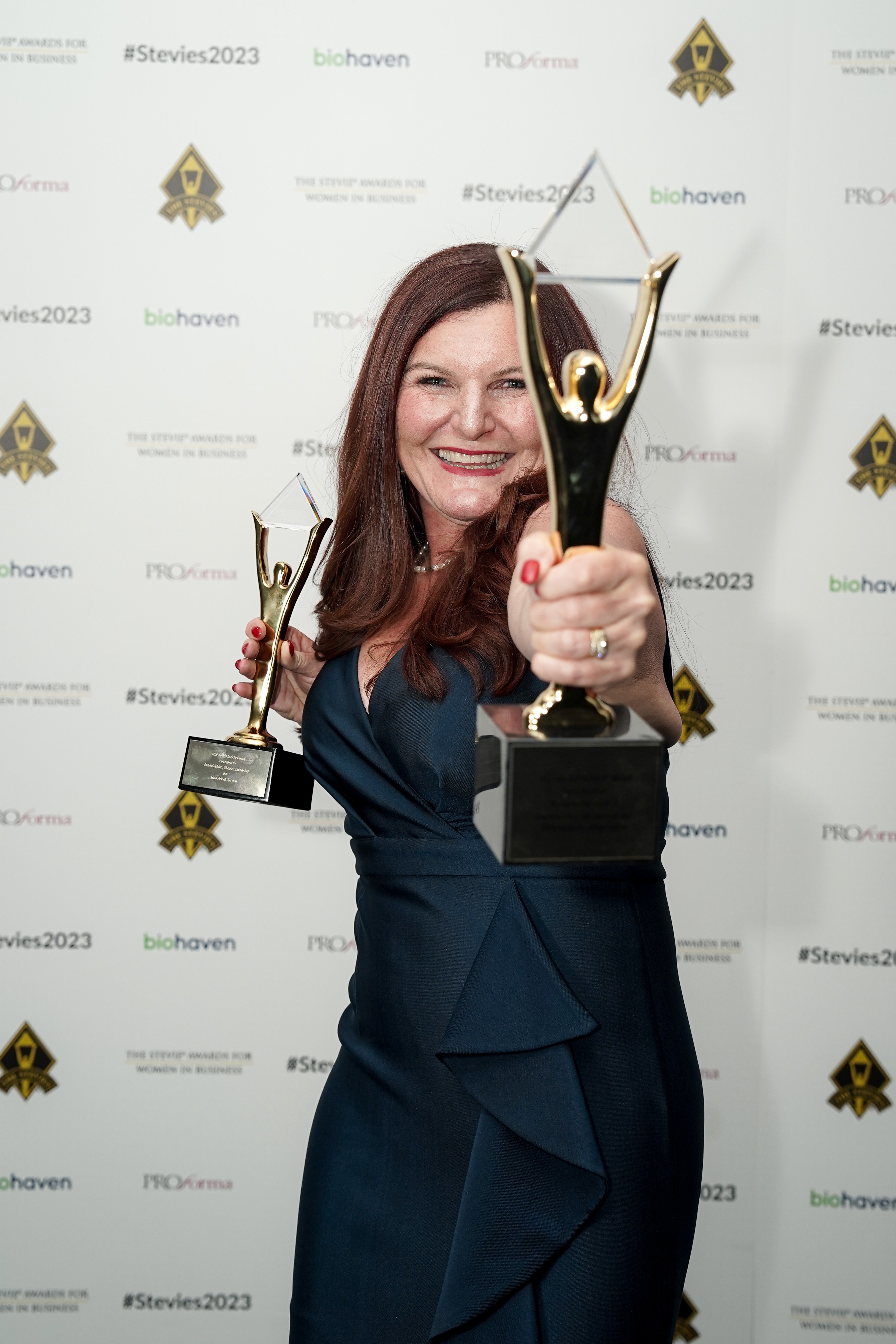 Annie Gibbins holding two Stevie Awards